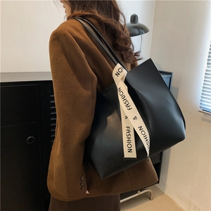 Grand sac cabas en cuir noir avec bandoulière contrastée 'FASHION', porté par un mannequin