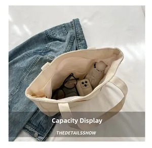 Vue de la capacité du grand sac fourre-tout en toile beige avec divers objets