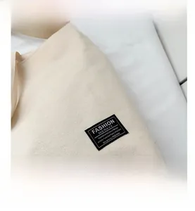 Detailed view of heavy canvas fabric texture and minimalist black woven label on tote bag