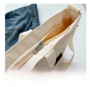 Close-up of smooth metal zipper closure and fabric lining on a canvas tote bag