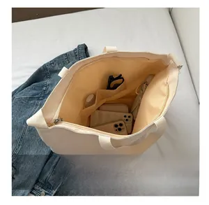 Detail view of large beige canvas tote bag showing interior storage space for essentials