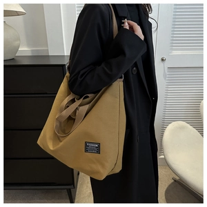 Detail of canvas tote bag showing the side view and the fashion instinct label detail