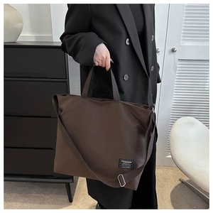 Detail of adjustable metal buckle and strap on dark brown canvas tote bag