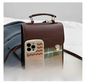 Dettaglio borsa vintage a quadri verdi con chiusura dorata e tracolla regolabile