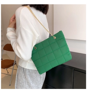Dettaglio della borsa shopper imbottita verde con catene dorate e trama in nylon