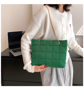 Dettaglio della borsa tote verde trapuntata con spalline a catena dorata elegante