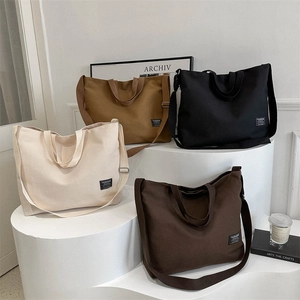 Minimalist canvas tote bag with double handles and fashion label in four neutral colors