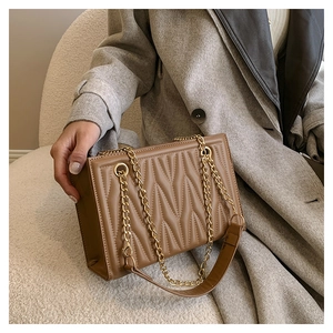 Detailed view of caramel brown quilted shoulder bag with elegant gold chain strap