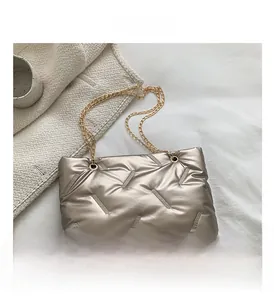 Nahaufnahme der silbernen Stepptasche mit goldenen Kettenriemen und feinen Nahtdetails