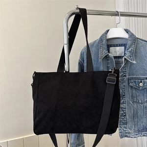 Classic black corduroy tote bag with dual handles and adjustable shoulder strap