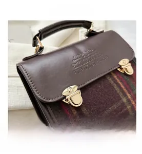 Detail view of vintage patchwork leather backpack with green plaid and gold buckles