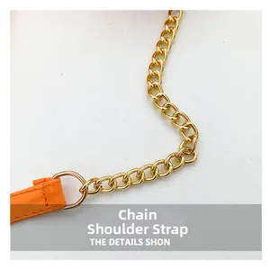 Detail of golden metal chain combined with orange lychee texture leather shoulder strap