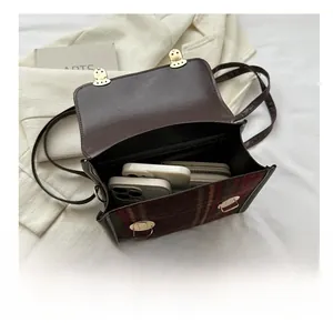 Detailed interior of vintage plaid wool handbag showing capacity for phones and wallet