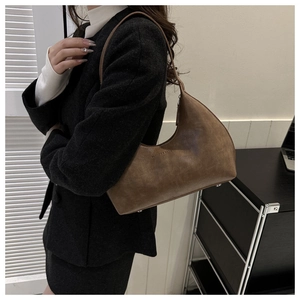 Gros plan du sac hobo marron vintage montrant la texture rétro et le texte gaufré