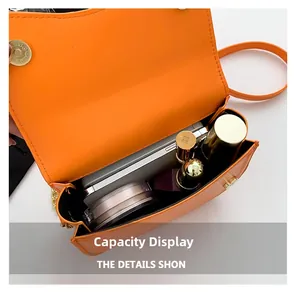 Interior view of orange leather saddle bag showing storage for phone and cosmetics