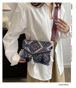 Close-up of bohemian crossbody bag with colorful ethnic patterns and fringe detail