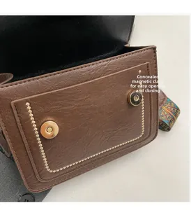 Detail of brown leather bag showing dual invisible magnetic snaps for easy opening