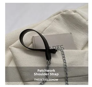 Close-up of a spliced shoulder strap featuring black leather and silver metal chain detail