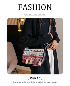 Detalle de bolso bandolera étnico con patrones geométricos, borlas y correa tejida