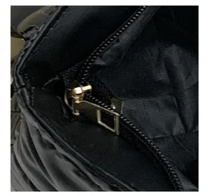 Macro shot of durable metal zipper and quilted nylon texture on black shoulder bag