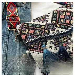 Detail of bohemian knit crossbody bag showing intricate geometric patterns and long tassels