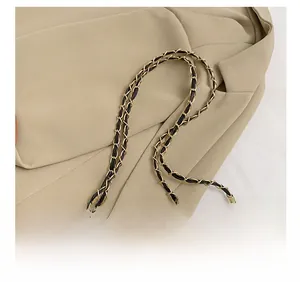 Close-up of black quilted shoulder bag featuring premium gold chain strap details