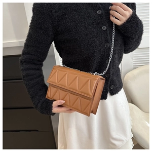 Brown quilted leather chain bag with geometric texture shown on a female model