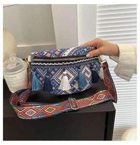 Detail of bohemian knit crossbody bag featuring multi-color fringes and jacquard wide strap