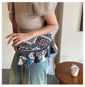 Detail of bohemian woven crossbody bag with geometric patterns and colorful tassels