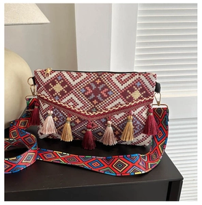 Close-up of bohemian knit crossbody bag with vibrant fringe and ethnic geometric patterns