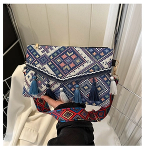 Detail of bohemian jacquard crossbody bag with geometric patterns and fringe tassels