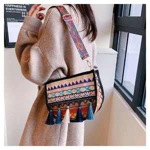 Vista detallada del bolso bandolera bohemio con borlas de colores y correa étnica