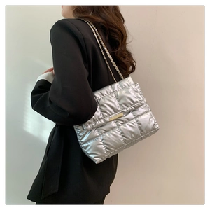 Detail of silver metallic quilted shoulder bag with gold chain strap and square buckle