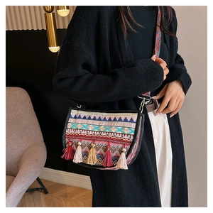 Detalle de bolso bandolera boho con bordado geométrico y borlas largas decorativas