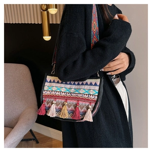 Detalle del bolso de hombro tejido étnico con borlas coloridas y patrones geométricos retro