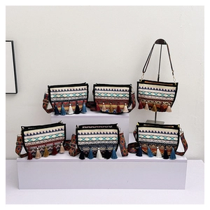 Detalle de bolsos bandolera étnicos con motivos geométricos y borlas de colores