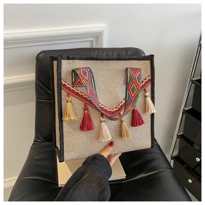 Détail d'un sac seau en lin ethnique avec des glands colorés et des motifs tissés à la main