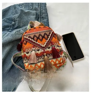 Detailed view of bohemian jacquard backpack with orange tassel and ethnic pattern strap