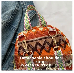 Detail view of ethnic orange crossbody bag featuring a removable shoulder strap with metal clip