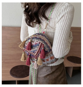 Detail of bohemian woven bag featuring vibrant geometric patterns and colorful tassels
