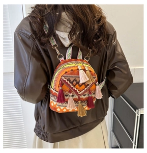 Detailed back view of a geometric woven backpack with colorful fringe tassels on model