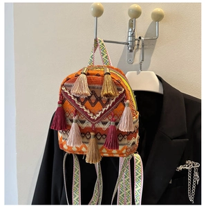 Detailed shot of ethnic woven handbag with colorful tassels and geometric straps