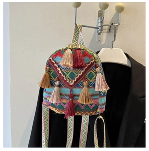 Close-up of bohemian woven bag with colorful geometric patterns and silk tassels detail