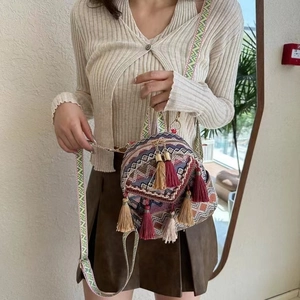 Detailed view of bohemian woven bag featuring colorful tassels and geometric patterns