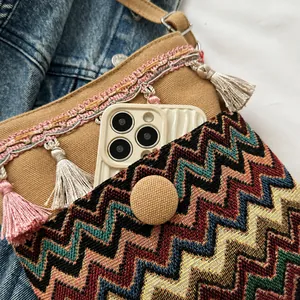Close-up of bohemian canvas bucket bag featuring colorful wave patterns and pink tassels