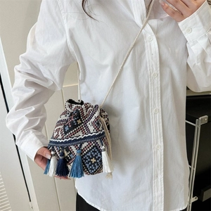 Detalle del bolso tipo saco bohemio con flecos y patrones geométricos étnicos