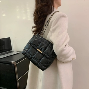 Quilted black leather shoulder bag with gold chain strap for minimalist office look
