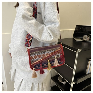 Gros plan du sac bohème avec motifs géométriques colorés et pompons décoratifs élégants