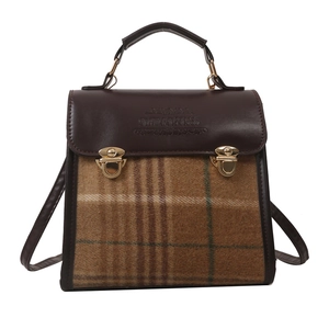 Vintage checkered backpack with brown leather trim and gold metal clasp in front view