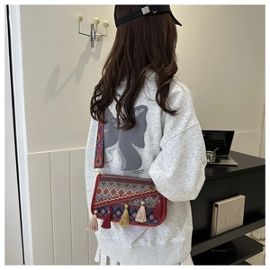 Vue détaillée du sac bandoulière ethnique avec pompons colorés et broderie